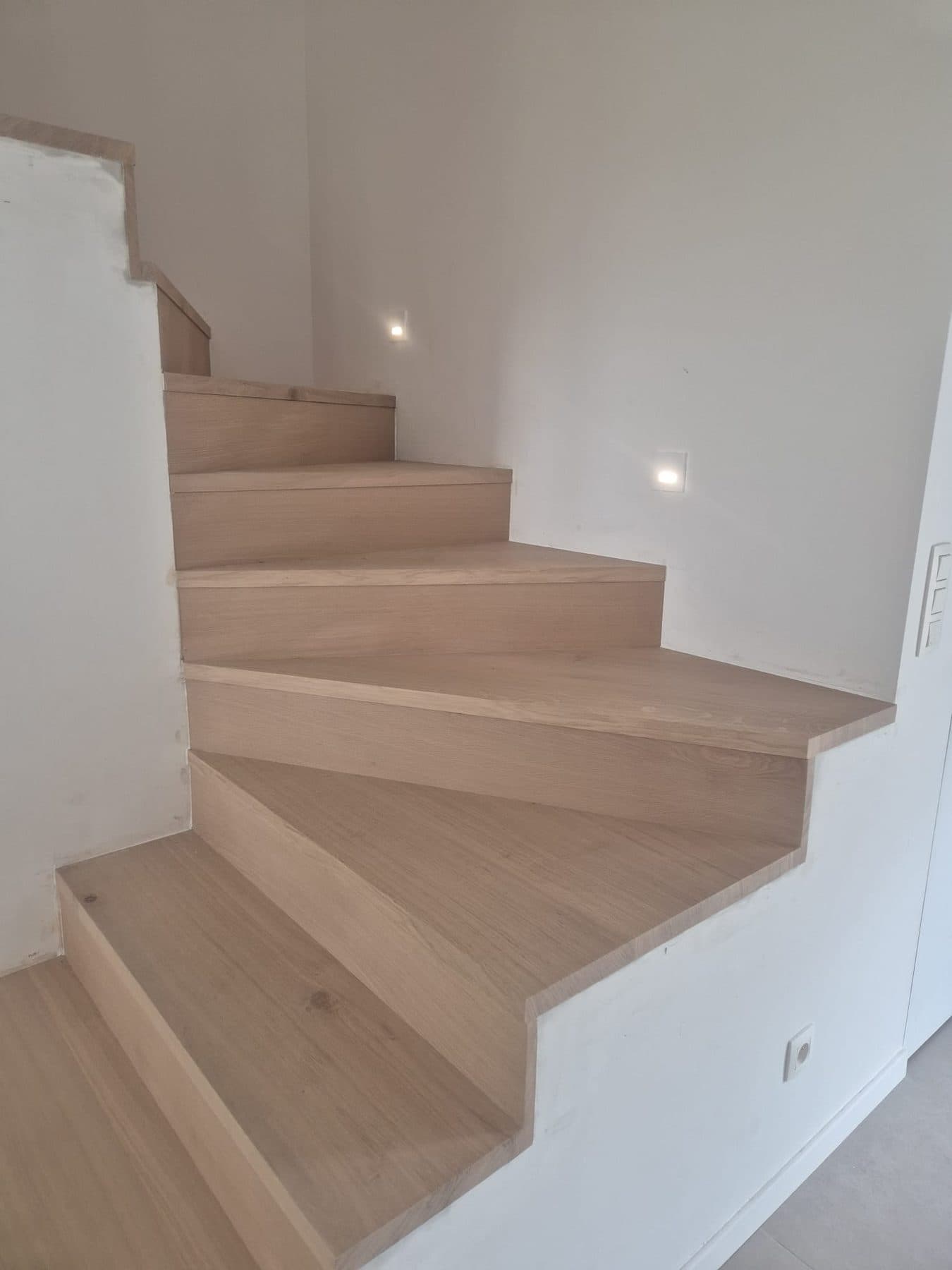 Escalier en chêne clair à marches balancées, spots encastrés