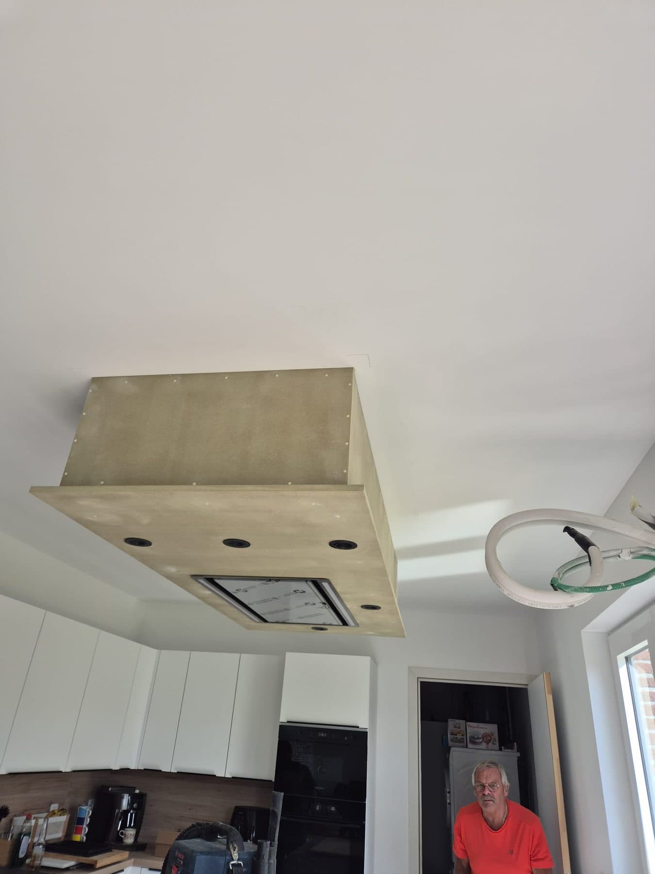 Caisson de hotte fixé au plafond d'une cuisine blanche