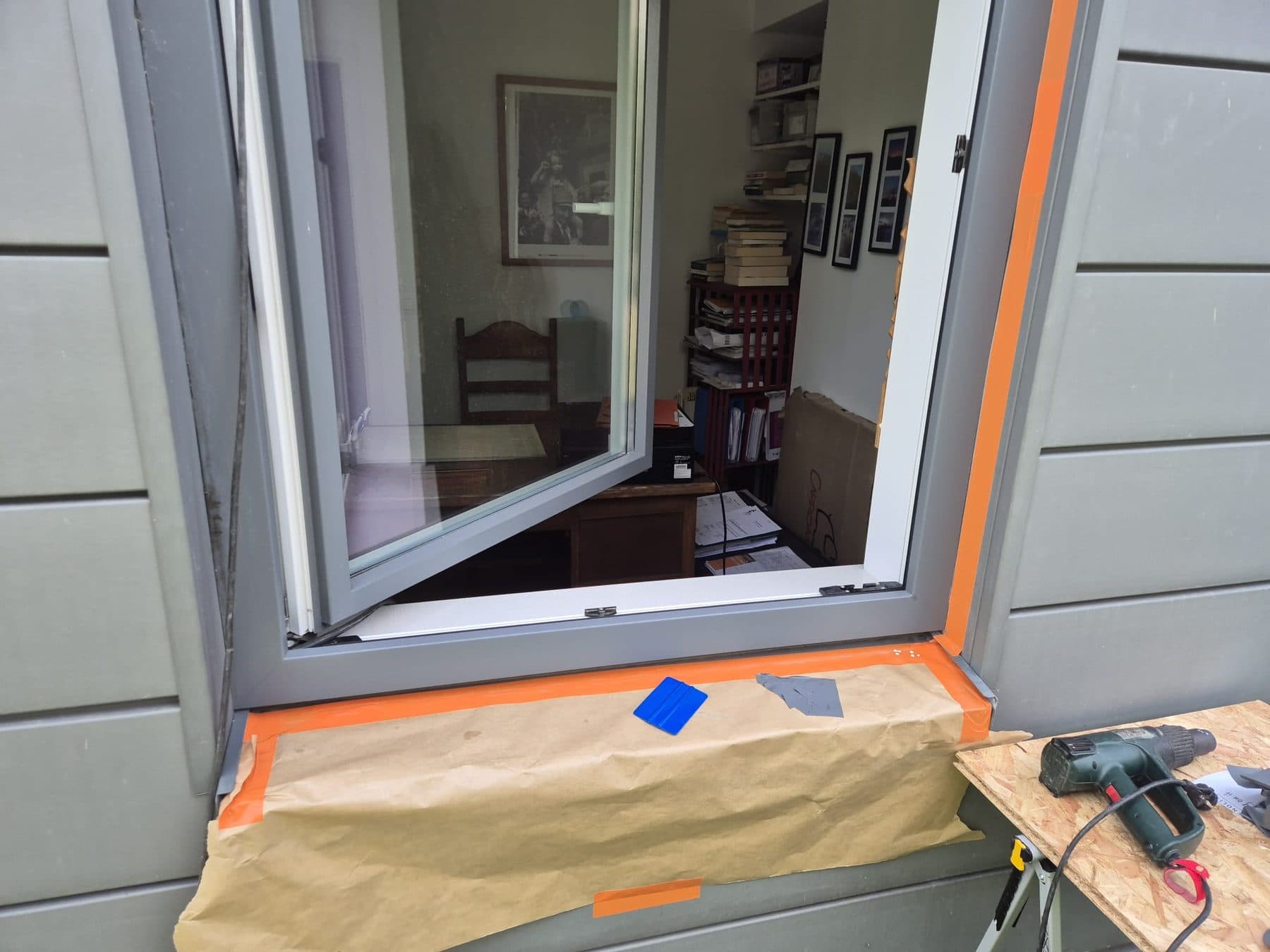Châssis posé dans un bardage gris, finition en cours